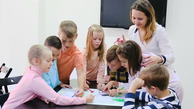Team of elementary age children  drawing on one sheet