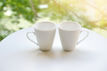 Two cup, tea or coffee on table garden bright background