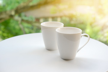 Two cup, tea or coffee on table garden bright background