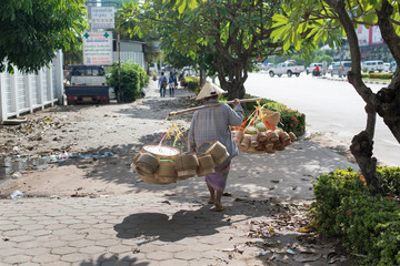 Unidentified women peddler hawker selling rice basket on the str