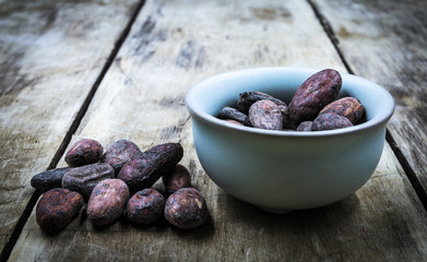 Raw cocoa beans on old wooden table