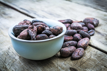 Raw cacao beans on old wooden table