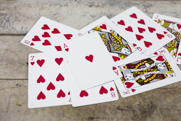 Detail of heart deck poker playing cars on wooden table