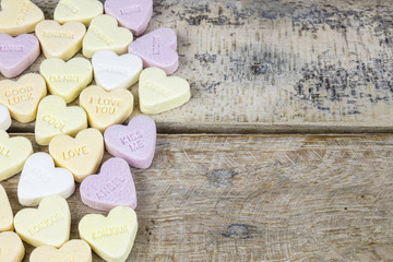 Obraz premium Group of sweet candies with heart shape on a wooden table
