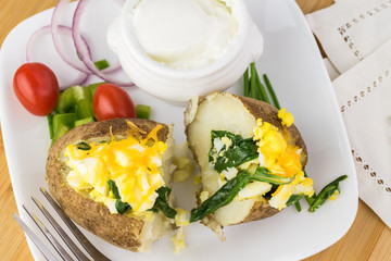 Loaded baked potato with eggs, spinach, cheese.