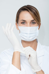 portrait d'une femme médecin qui met des gant en latex