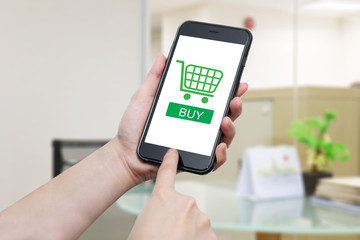 hand using smart phone with buy button and  the shopping cart on