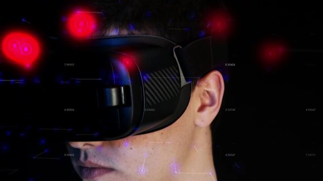 Close-up shot of a young man wearing VR Headset experiencing virtual reality. 3D objects flying around head.