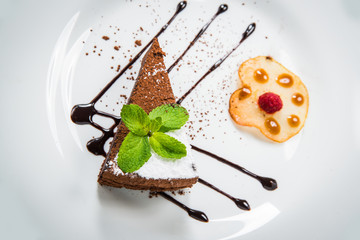Delicious chocolate cake on plate on table on light background
