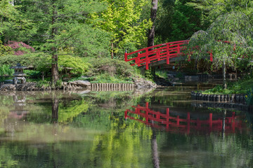 Beautiful Japanese garden with red arched bridge over reflective water.  Sarah P. Duke.  