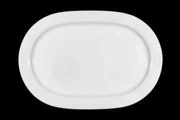 Flat white shallow porcelain oval plate with shoulders on wooden cutting board directly from above