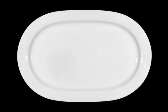 Flat white shallow porcelain oval plate with shoulders on wooden cutting board directly from above