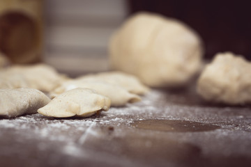 Fototapeta na wymiar Homemade Dumplings prepared on the wooden brown table by traditional way