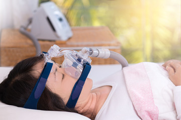 Obstructive sleep apnea therapy, Woman wearing CPAP mask.CPAP Continuous positive airway pressure  therapy.Happy and healthy senior woman breathing more easily during sleep  without snoring.