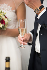 Groom is holding a glass of champagne.