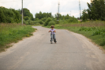 girl child riding  scooter on  road in rural areas, concept of c
