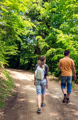 Young woman and man walking in the forest in summer