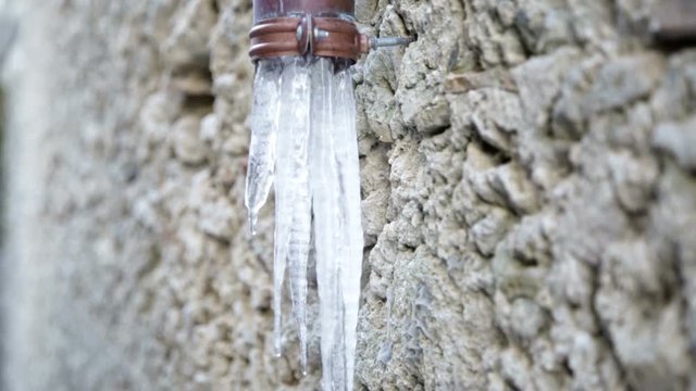 Stalattiti di acqua ghiacciata che escono fuori dalle grondaie delle case