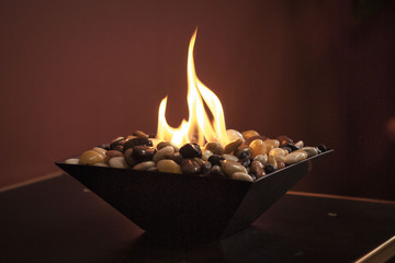 Burning eco fireplace with decorative stones. Romantic interior.