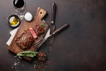 Rolgordijnen Grilled ribeye beef steak with red wine, herbs and spices © karandaev