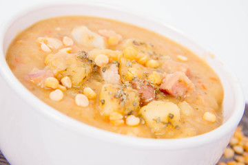 Split pea soup, decorated with some bay leaves, marjoram and peas