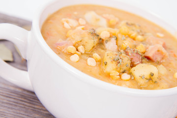 Split pea soup, decorated with some bay leaves, marjoram and peas
