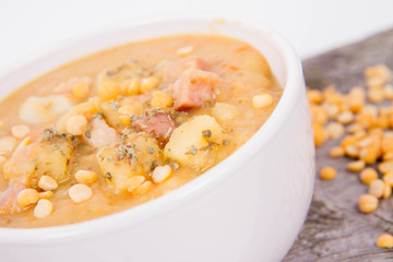 Split pea soup, decorated with some bay leaves, marjoram and peas