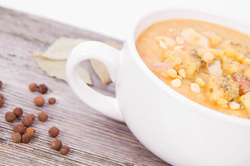 Split pea soup, decorated with some bay leaves, marjoram and peas
