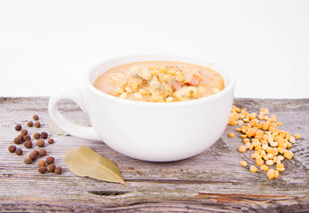 Split pea soup, decorated with some bay leaves, marjoram and peas