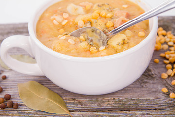 Split pea soup, decorated with some bay leaves, marjoram and peas