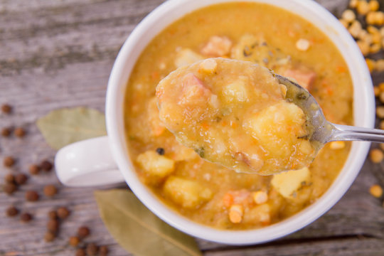 Split pea soup, decorated with some bay leaves, marjoram and peas