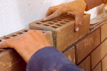 Bricklayer lays bricks under unravel. construction work