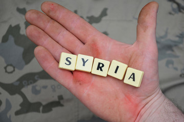 letters with text syria on a dirty hand. concept