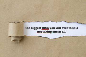 The biggest risk you will ever take is not taking one at all message written under torn paper.