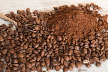 Spilled coffee beans and ground on a table.