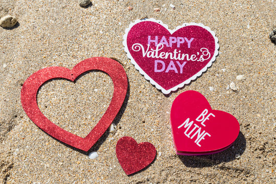Happy Valentine's day from beach/Glitter Happy Valentine's Day Sign and red glitter hearts on the sandy beach