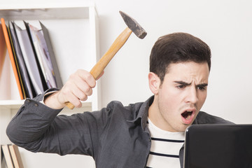 young man with the hammer hitting the laptop computer © carballo