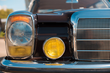 Fragment of the front of the vintage car headlights and radiator