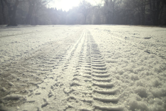 След от машины на снегу в зимний день.