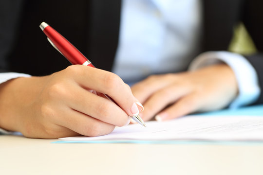 Businesswoman hands writing in a document