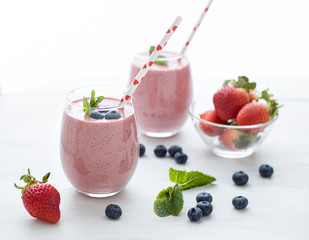 Stylish glasses of healthy smoothies with strawberry and blueberry. Morning breakfast for two....