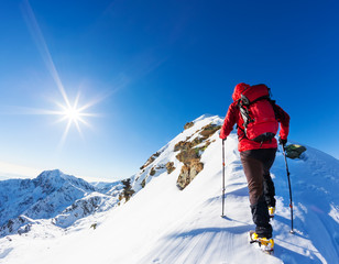 Extreme wintersport: klimmer op de top van een besneeuwde top in de Alpen. Concepten: vastberadenheid, succes, dapper.