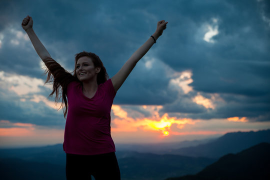 woman gesturing success - silhouette over evening sky