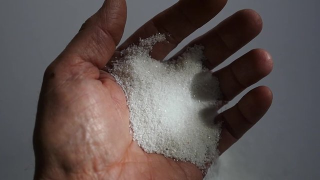 Sand runs through a mans fingers in slow motion