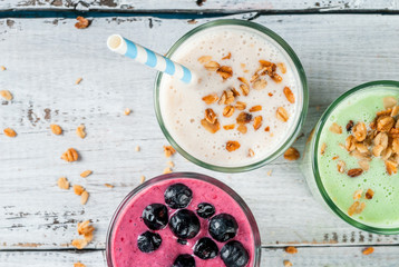 Refreshing milkshakes or smoothies: White (banana), green (apple and kiwi) and berries. On a white...