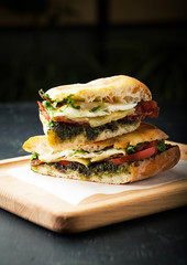 Tasty sandwich with meat, fried egg, cheese and pesto