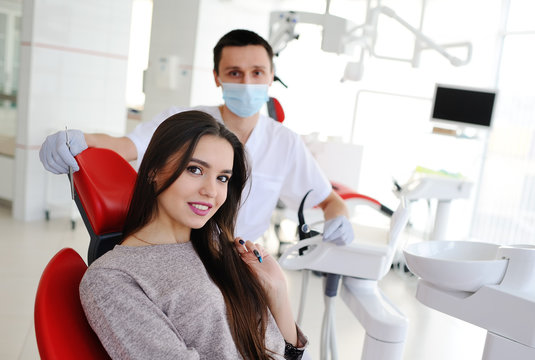 beautiful girl patient with a white healthy teeth looking in the camera. dentist prepares for a patient examination. Dentist prepares for a patient examination