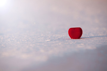 Fototapeta premium Beautiful romantic red heart box on a white snow.