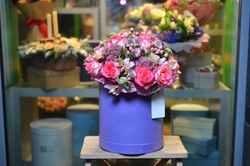 Bouquet of roses in a purple box in the background showcases flower shop