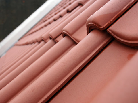 Dachsanierung: Neue Dachziegel, neue Dachpfannen vor unsanierter Brandmauer